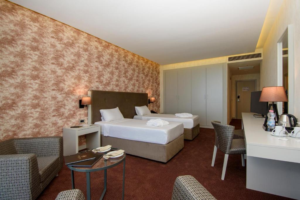 Grezna viesnīcas istaba ar divām gultām, mūsdienīgu dizainu un ērtu sēdvietu, kas nodrošina patīkamu atpūtu. Interjers ir ar siltām krāsām un modernām mēbelēm, radot mājīgu atmosfēru.