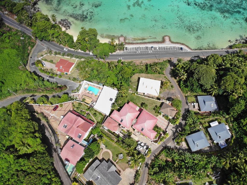 Skats no augšas uz krastmalu ar viesnīcām, baseinu un zaļo dabu. Skaista pludmale un skaidrs ūdens veido idillisku ainavu.