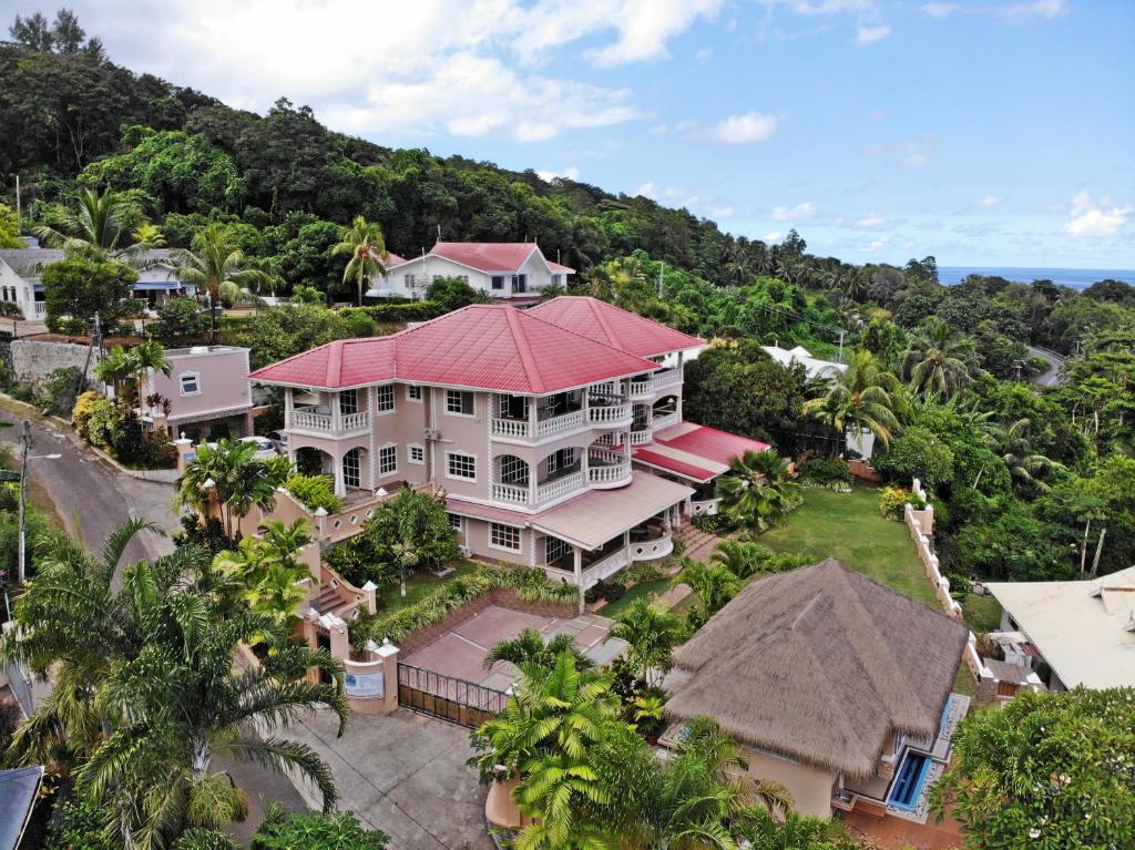 Lieliska piejūras villa ar sarkanu jumtu, ieskauta zaļiem kokiem un dārziem, piedāvā skatu uz tuvējo jūru un kalniem. Ēka ir moderna un plaša, ar lielu pagalmu un piekļuvi šaurām ielām.