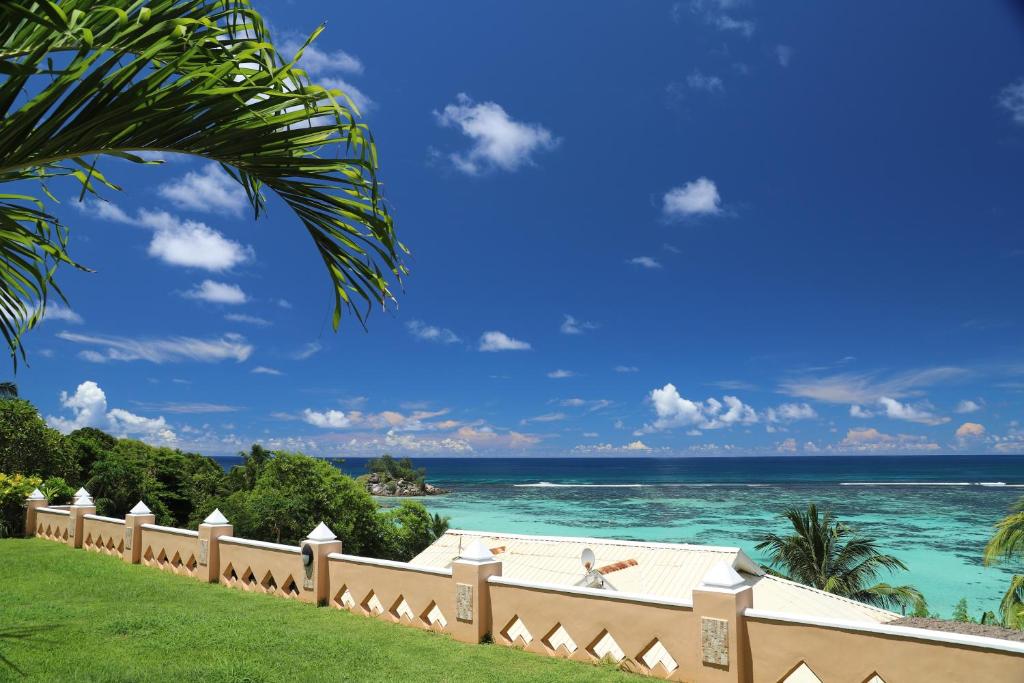 Skaista pludmales ainava ar zilo okeānu un baltām mākoņu debesīm, ko papildina zaļojošas palmas un apzaļumota teritorija. Ideāla vieta atpūtai un relaksācijai.