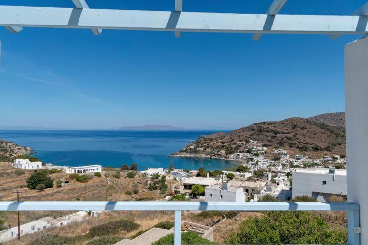 Skats uz mierīgu jūru un kalnainu piekrasti, ar baltām mājām, kas izvietotas pa kalnu nogāzēm. Klaras debesis un saulaina diena.