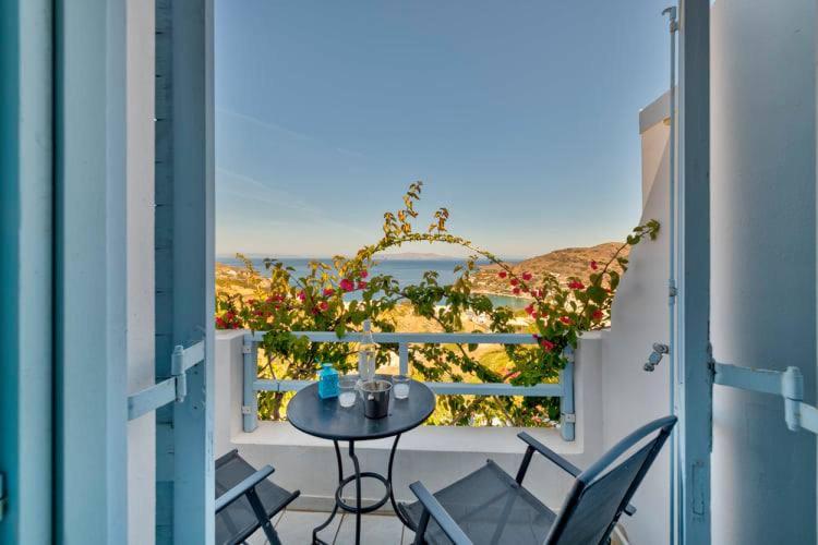 Balkons ar skatu uz jūru, kurā ir neliels galds un divas krēsli, apzaļumots ar ziediem. Ideāla vieta relaksācijai un ainavas baudīšanai.