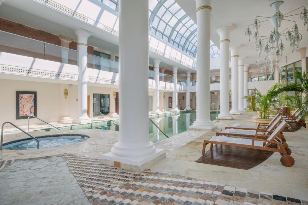 Mūsdienīgs spa komplekss ar elegantiem stabiem, relaksējošām sauļošanās vietām un baseinu, kas apgaismots ar dabiskiem saules stariem. Ideāla vieta atpūtai un labsajūtai.