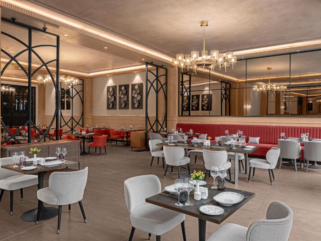 Elegants restorāns ar modernu interjeru, kurā ir stilīgas galdi un krēsli, siltas krāsas un izsmalcināti apgaismojumi. Ideāla vieta, kur baudīt maltīti patīkamā atmosfērā.