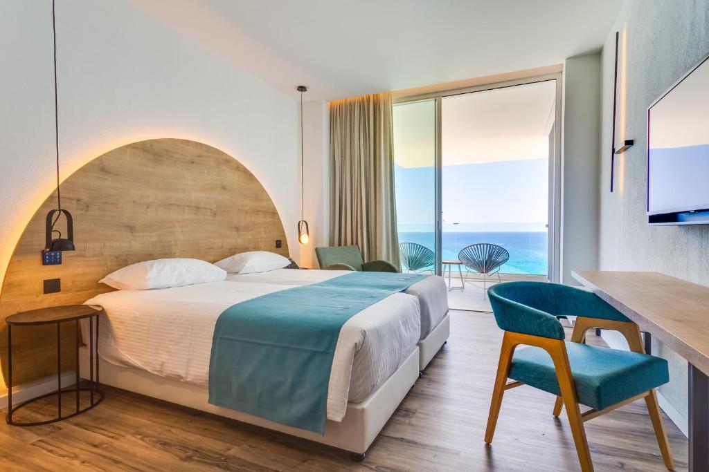 Mūsdienīgs viesnīcas numurs ar divām gultām, koka sienas apdari un skatu uz jūru. Numurā ir balkons, televizors un stilīgas mēbeles, kas nodrošina komfortablu atpūtu.