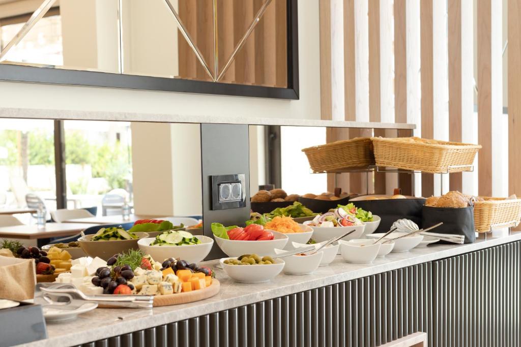 Bagātīgas brokastu izvēles galds ar svaigiem dārzeņiem, augļiem un maizēm. Ideāls brīdis, lai izbaudītu veselīgu maltīti.