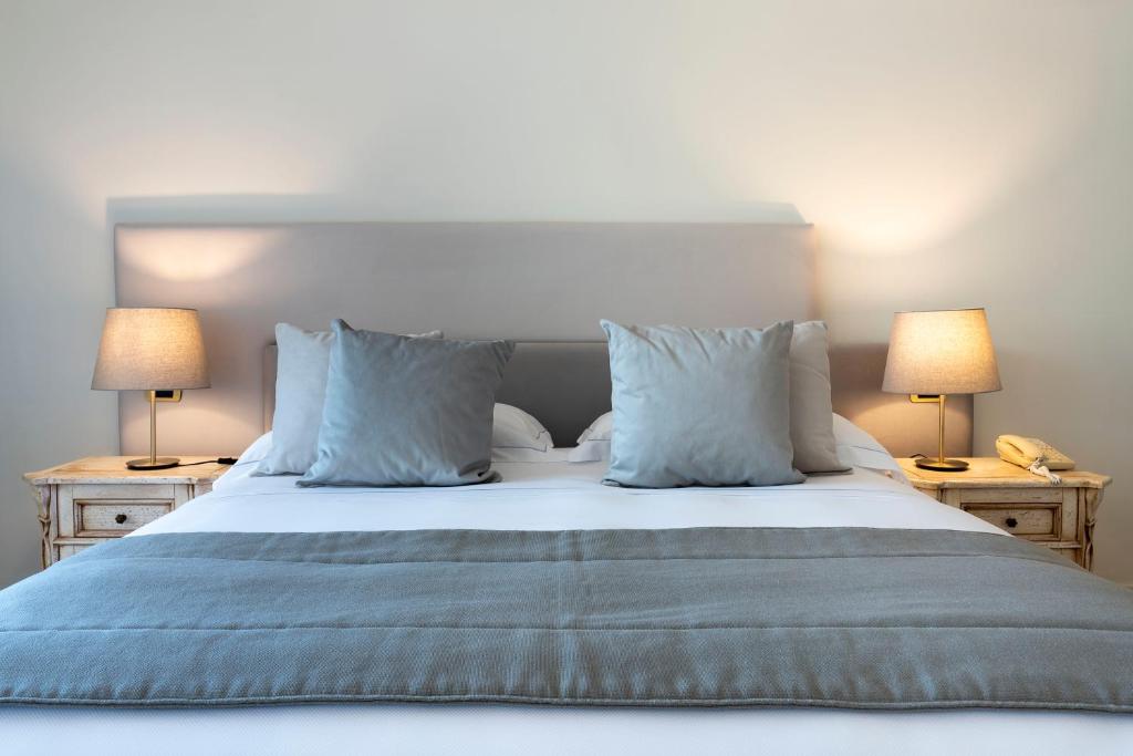 Mūsdienīgs guļamistabas interjers ar ērtu gultu, dekoratīvām spilveniem un siltu apgaismojumu. Ideāla vieta atpūtai un relaksācijai.