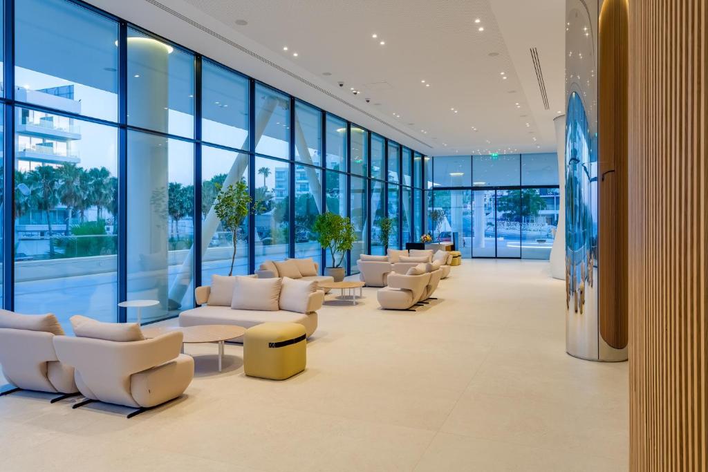 Moderns interjers ar plašām logu sienām, stilīgām mēbelēm un zaļām augiem, radot mierīgu atmosfēru. Ideāli piemērots atpūtai un socializācijai.