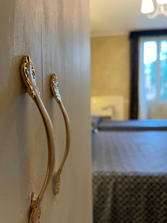 Eleganti rokturi uz sienas, kas piešķir stilīgu akcentu istabas interjeram. Fons ar gultu un logu, radot mājīgu atmosfēru.