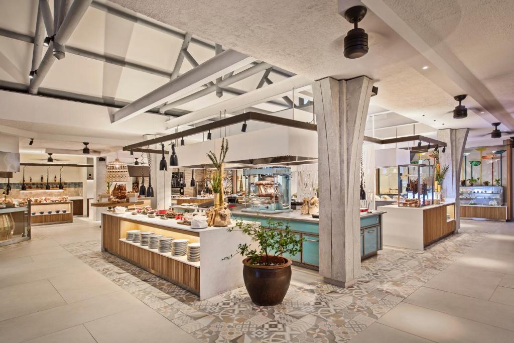 Mūsdienīgs bufetes restorāns ar elegantu interjeru, kas piedāvā plašu ēdienu izvēli un stilīgu dekoru. Apgaismojums un arhitektūra rada patīkamu atmosfēru.