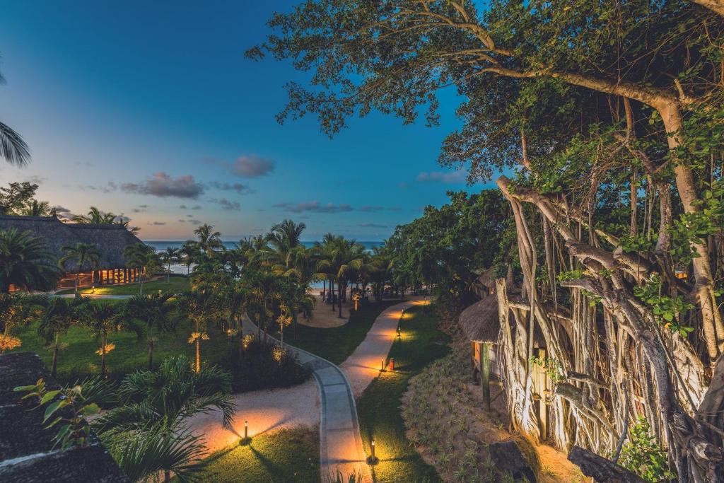 Tropu ainava ar apgaismotu taku, palmām un jūras skatu, kas radītas saulrieta gaismā. Ideāla vieta relaksācijai un atpūtai.