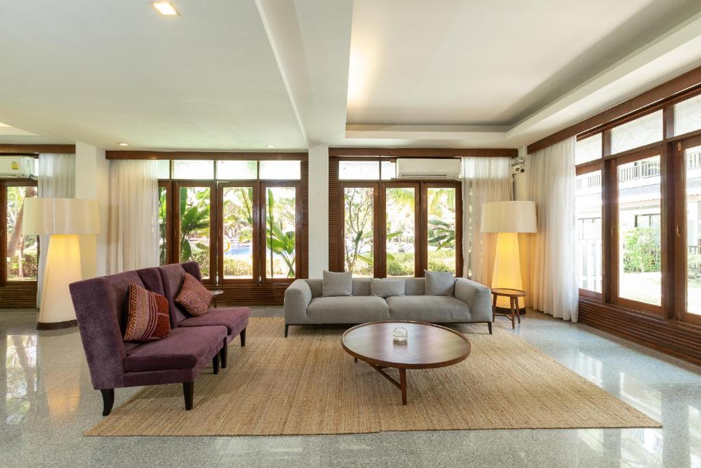 Mūsdienīgs viesistabas interjers ar gaišām krāsām, diviem dīvāniem un apaļu galdu, apgaismots ar dabīgu gaismu no lielajiem logiem. Rūpīgi iekārtots, radot patīkamu un relaksējošu atmosfēru.