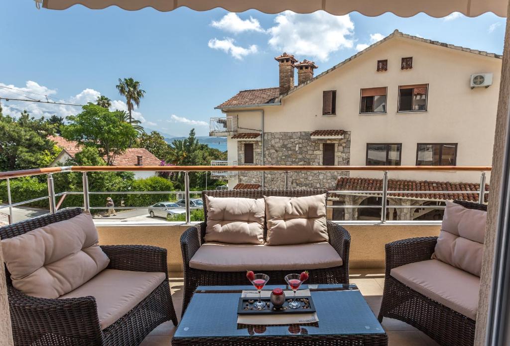 Balkons ar ērtām mēbelēm un skatu uz jūru, apzaļumotām teritorijām un tuvāko ēku. Ideāla vieta relaksācijai un atpūtai.