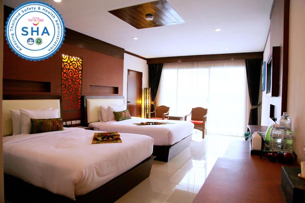 Moderni numuri Chivatara Resort Bangtao ar divām gultām un balkonu.