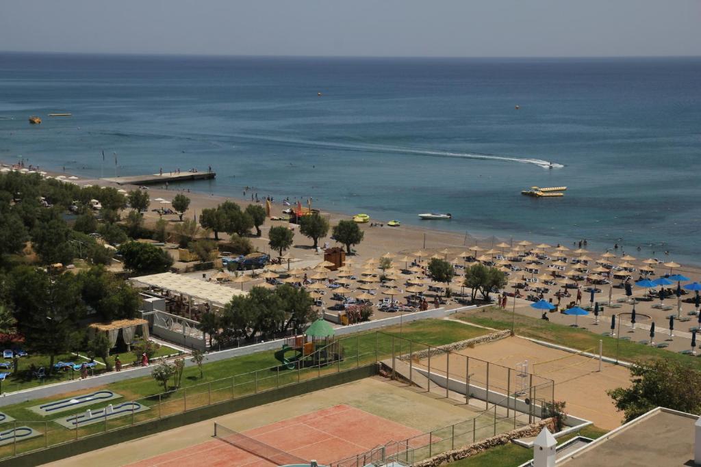 Olympos Beach Hotel pludmales zona ar tenisa kortiem un atpūtas iespējām pie jūras.