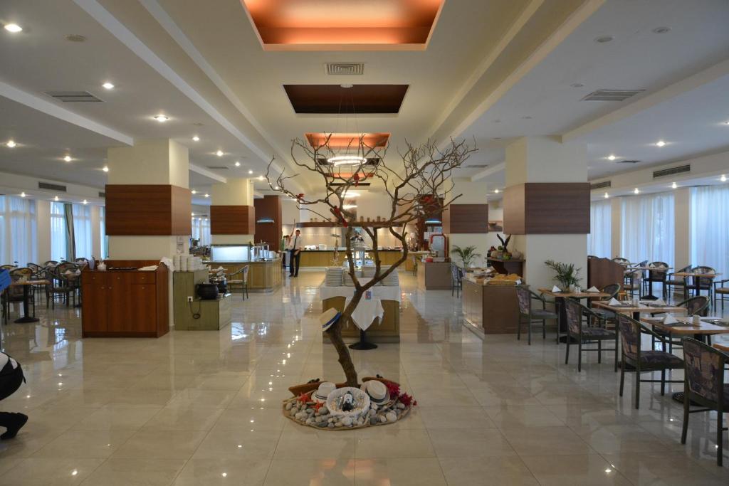 Plaša Olympos Beach Hotel ēdamzāle ar bufetes zonu un elegantu interjeru.