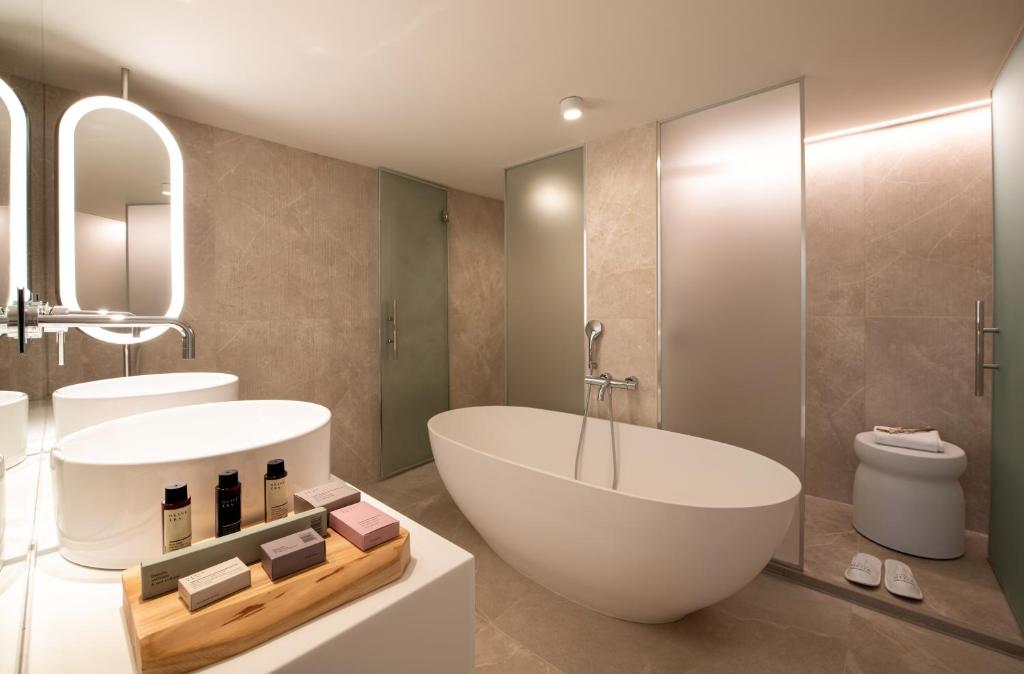 Mūsdienīgs vannas istabas interjers ar elegantu brīvstāvošu vannu, stilīgu izlietni un augstas kvalitātes higiēnas produktiem. Gaismas un modernu materiālu kombinācija rada relaksējošu atmosfēru.