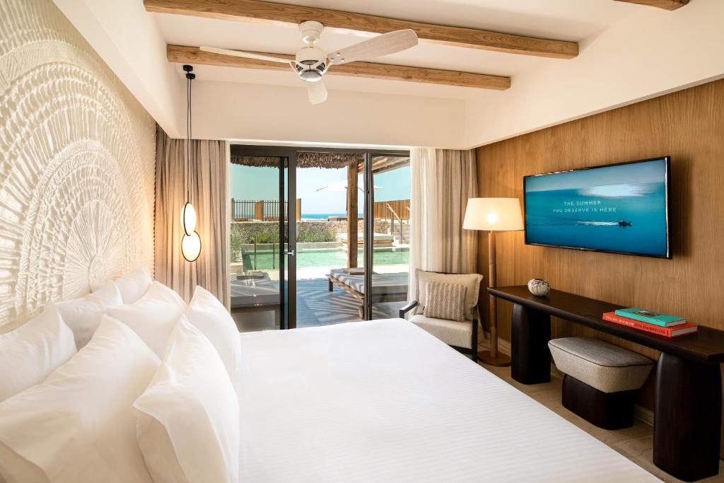 Moderns viesnīcas numurs ar plašu gultu, lielu logu un piekļuvi terasei. Telpā ir gaisa ventilators un televizors, radot relaksētu atmosfēru.