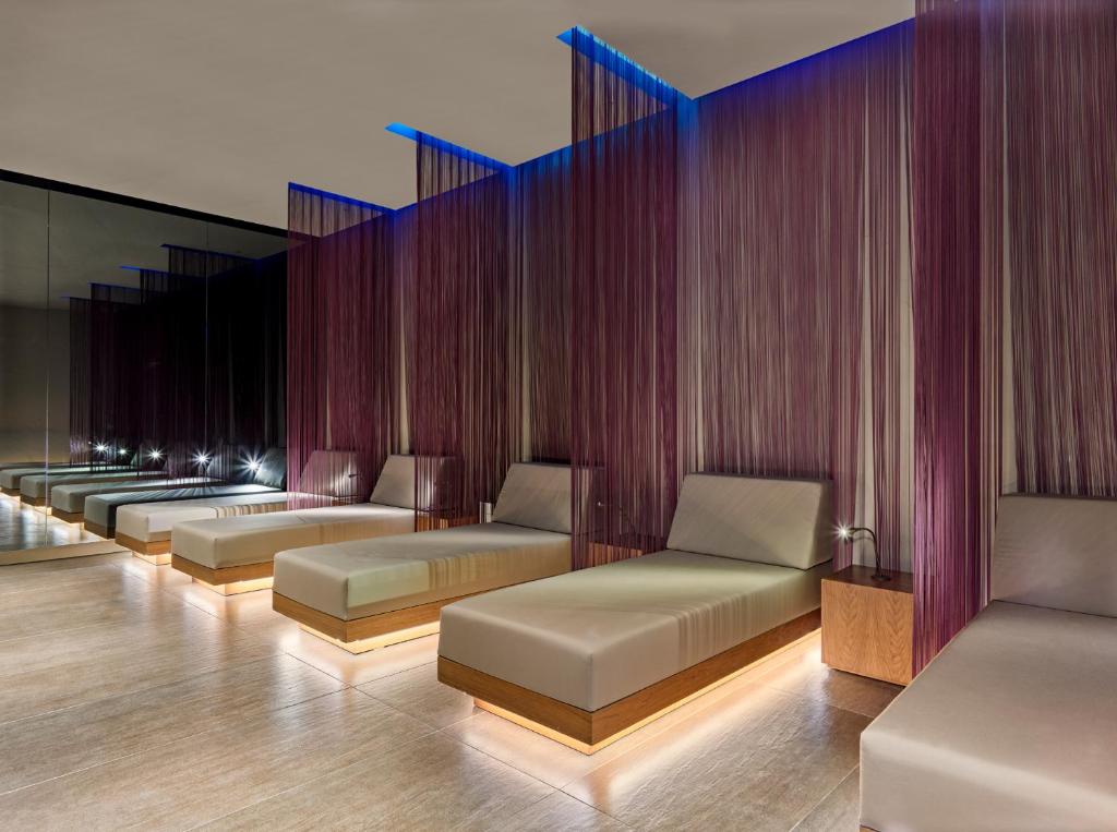 Mūsdienīgs spa atpūtas zona ar ērtām guļamvietām un stilīgām violetām aizkariem, kas rada relaksējošu atmosfēru. Apgaismojums akcentē interjera eleganci un mierīgumu.