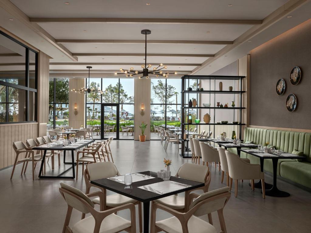 Mūsdienīgs restorāns ar plašu interjeru, kas piedāvā elegantu atmosfēru un skatu uz dārzu. Gaišās krāsās veidotie galdi un krēsli rada patīkamu vidi.