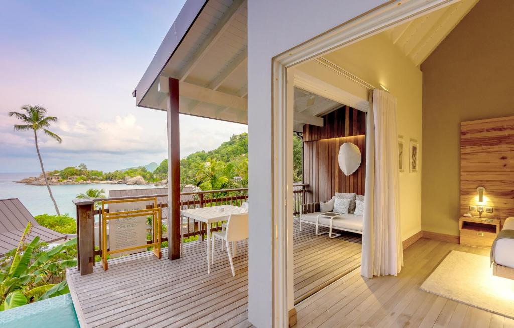 Mūsdienīgs viesnīcas numurs ar terasi un skatu uz jūru, kurā ir mēbelēta atpūtas zona un dabiskais apgaismojums. Apkārtne ir zaļa un eksotiska, radot relaksējošu atmosfēru.