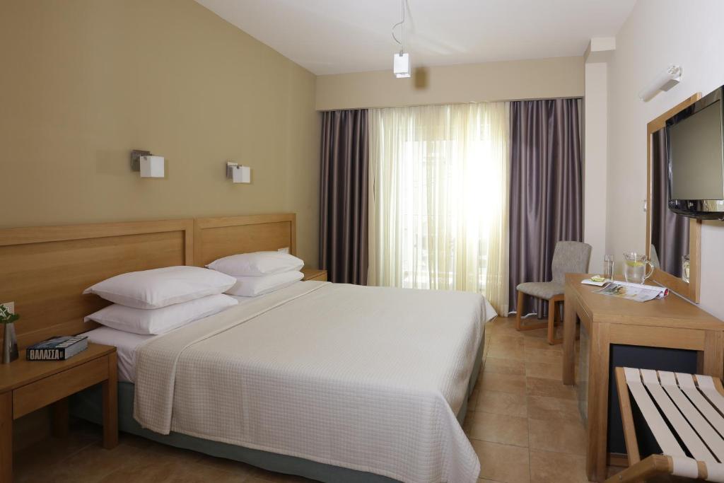 Mūsdienīga viesnīcas numura iekšskats ar divguļamo gultu, koka mēbelēm un dabīgu apgaismojumu. Numurā ir televizors un rakstāmgalds, kas piedāvā komfortablu atpūtu.