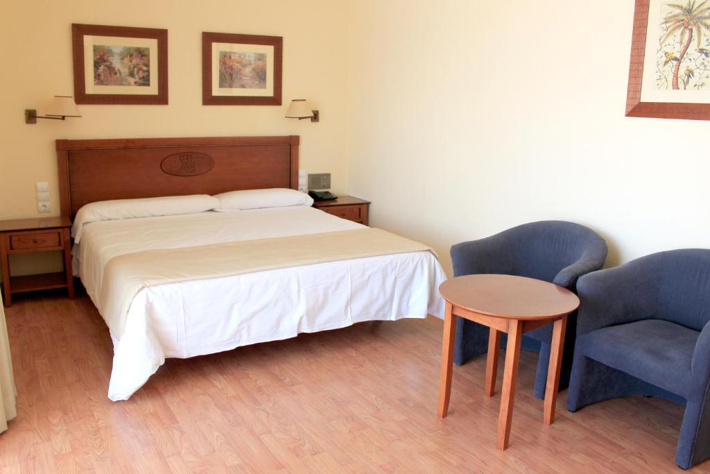 Mūsdienīgs viesnīcas numurs ar divguļamo gultu, koka mēbelēm un ērtu sēžamo stūri, kas nodrošina relaksējošu atmosfēru. Sienās ir gleznas, kas piešķir telpai mājīgu raksturu.