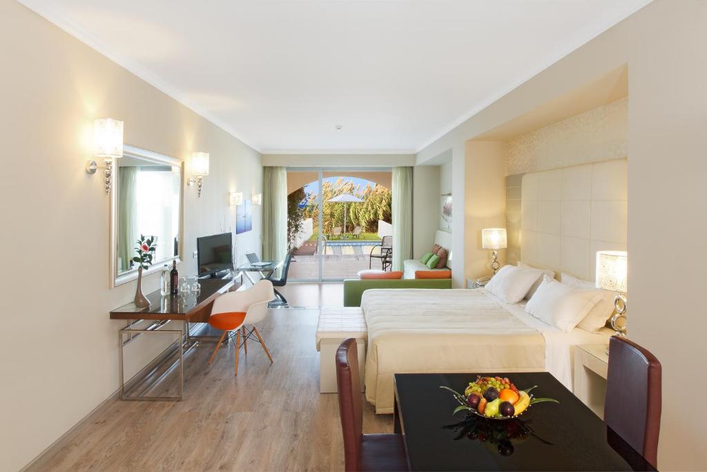 Mūsdienīga viesnīcas numura iekšpuse ar ērtu gultu, dzīvojamo zonu un balkonu, no kura paveras skats uz dārzu. Interjers ir gaišs un elegant, ar modernām mēbelēm un aksesuāriem.