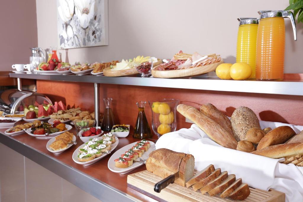 Bagātīgs brokastu bufete ar dažādiem ēdieniem, tostarp maizi, augļiem, salātiem un dzērieniem. Ideāli piemērota, lai sāktu dienu ar veselīgu un garšīgu maltīti.