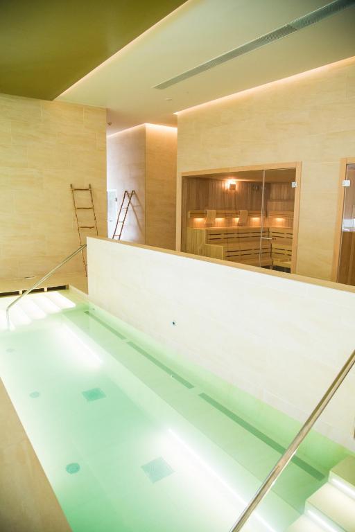 Mūsdienīga spa zona ar relaksējošu ūdens baseinu un saunu, kas piedāvā mierīgu atmosfēru un labklājību. Ideāla vieta atpūtai un relaksācijai.