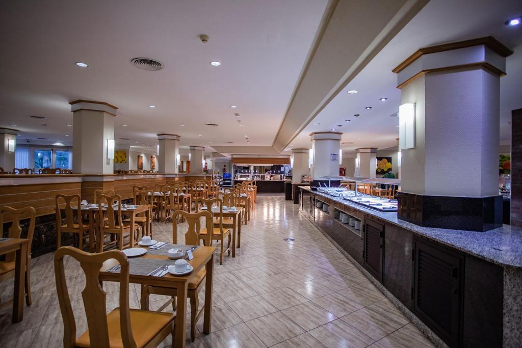 Gaisma un plaša restorāna telpa ar koka mēbelēm un bufetes galdu, piedāvājot ēdienus. Ideāli piemērota ēdināšanas pakalpojumiem un viesu apkalpošanai.