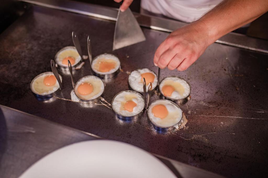 Vistas olas tiek gatavotas uz grila, izmantojot metāla formiņas. Šefpavārs uzmanīgi apstrādā olas ar speciālu instrumentu.