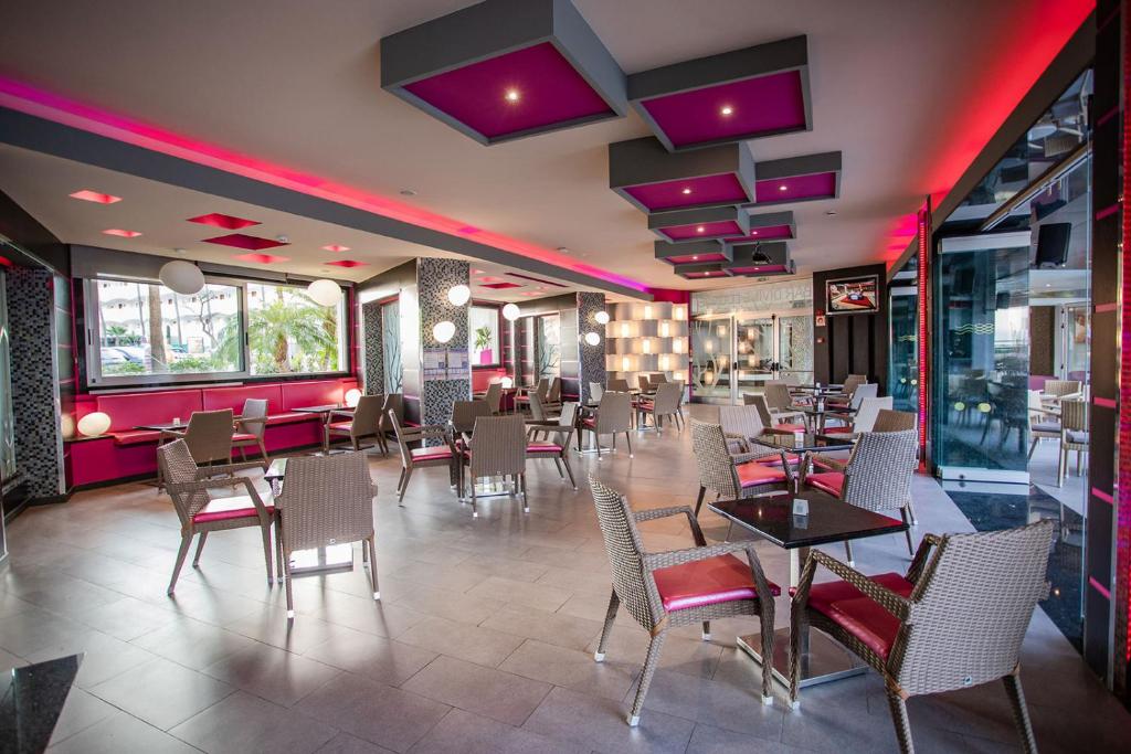 Mūsdienīgs restorāns ar siltu apgaismojumu un stilīgu interjeru, kurā ir ērtas viesu sēdvietas un eleganti galdi. Izceliet modernās krāsas un dizaina elementus.