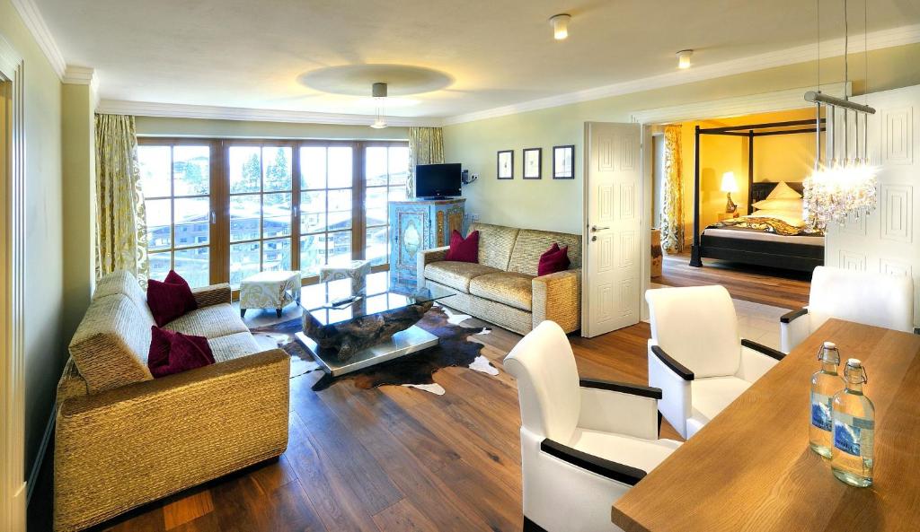 Mūsdienīgs viesnīcas numurs ar viesistabu un guļamistabu, kurā ir ērti dīvāni, elegantas mēbeles un lieli logi, kas nodrošina dabīgu apgaismojumu.