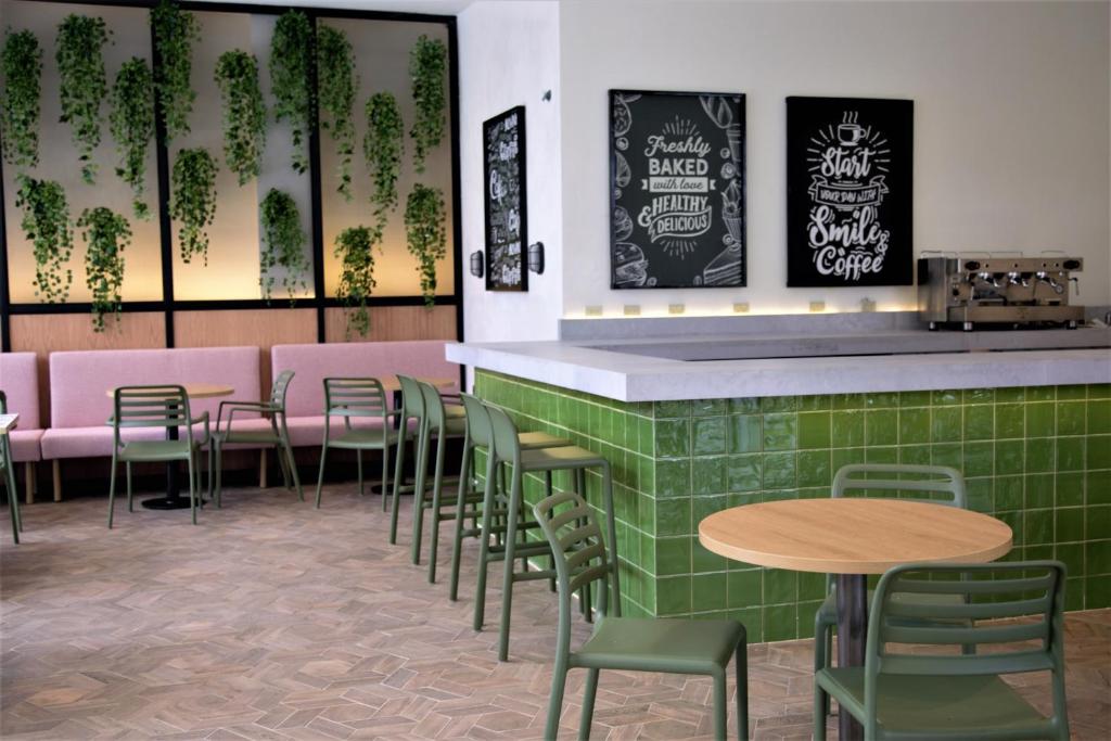 Mūsdienīga kafejnīca ar zaļu flīžu bāru, gaišiem koka galdiem un krēsliem, kā arī pievilcīgiem augu dekoriem. Uz sienām redzami iedvesmojoši uzraksti par kafiju un veselīgu ēšanu.