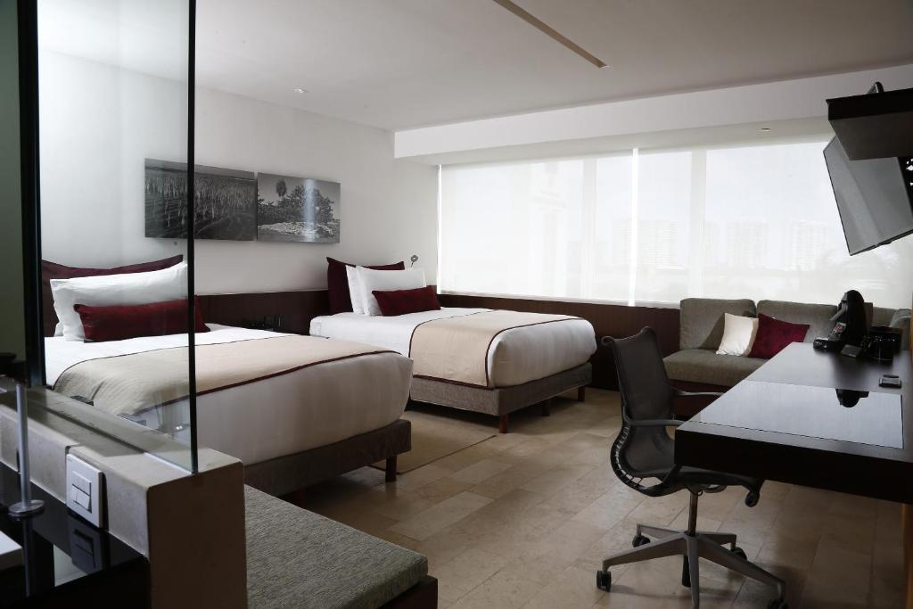 Mūsdienīgs viesnīcas numurs ar divām gultām, darba galdu un ērtu atpūtas stūrīti. Labi apgaismots ar lieliem logiem un minimālistisku dizainu.