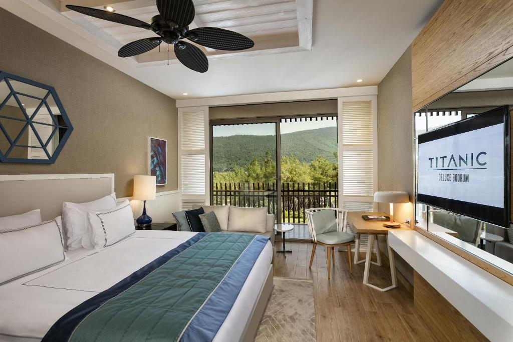 Mūsdienīgs numurs Titanic Luxury Collection Bodrum ar balkonu un skatu uz kalniem.
