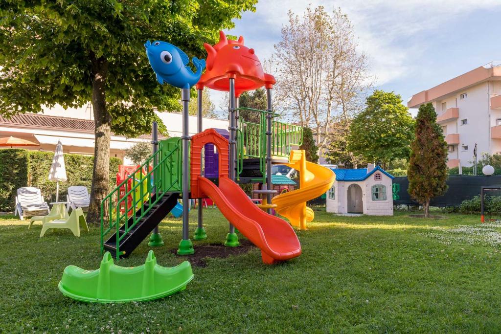 Krāsains bērnu rotaļu laukums ar slidkalniņiem un kāpņu konstrukciju, apzaļumota teritorija ar zālienu un bērnu mājiņu. Ideāla vieta bērnu spēlēm un izklaidei.