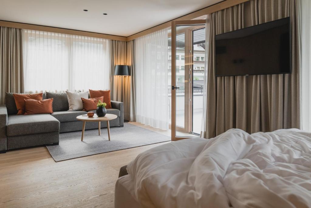 Mūsdienīga viesnīcas numura interjers ar dīvānu, galds un televizors. Lielas logu aizkari un balkona durvis nodrošina daudz gaismas un piekļuvi āra terasei.