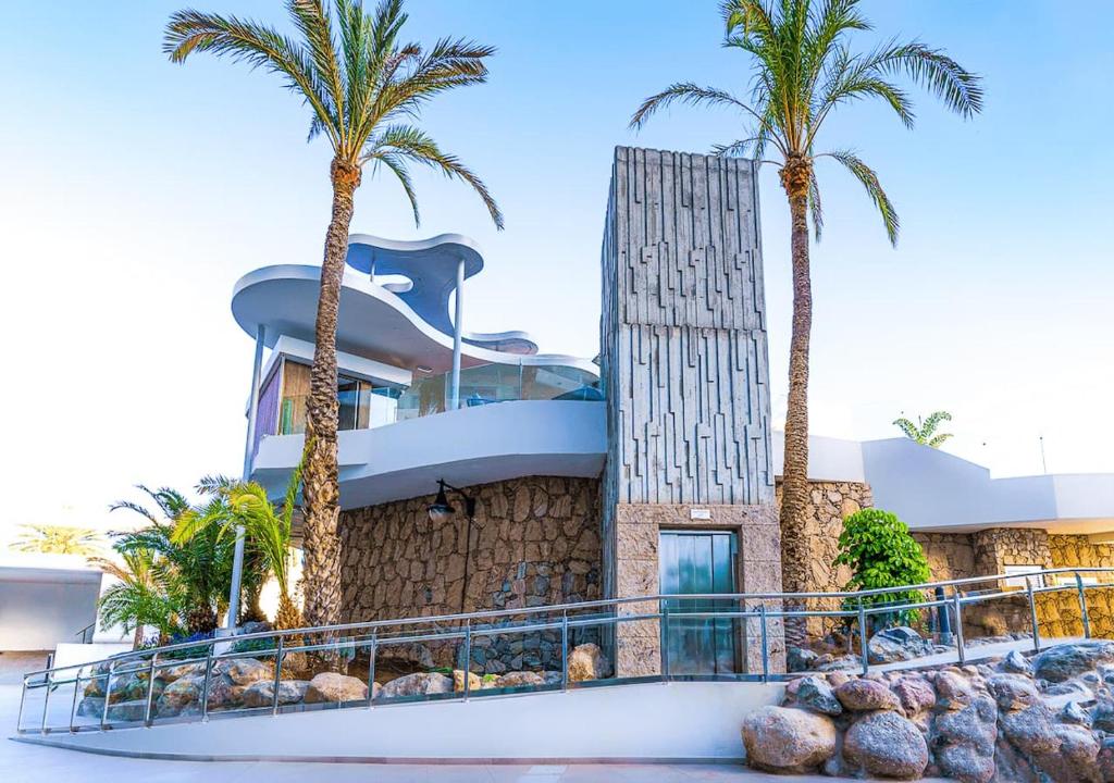 Mūsdienīga arhitektūra ar palmām un akmeņu detaļām, kas veido pievilcīgu ainavu. Ideāla vieta atpūtai un relaksācijai.