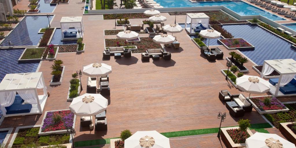 Elegants baseina zona ar atpūtas kabīnēm un saulessargiem, ieskauta ziedu dobēm un gleznainiem laukumiem. Rūpīgi veidots ainavu dizains, kas rada mierīgu atmosfēru.