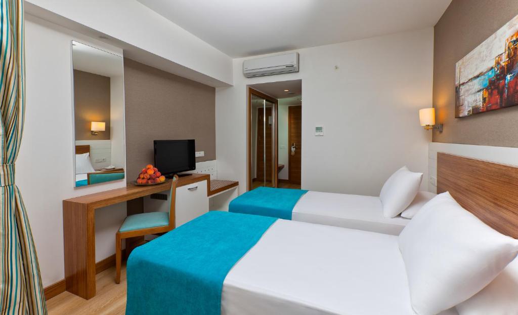 Mūsdienīgs viesnīcas numurs ar divām gultām, rakstāmgaldu un televizoru, kā arī ar gaisīgu interjeru un dekoratīvām gleznām. Numurā ir arī spogulis un augļu grozs.