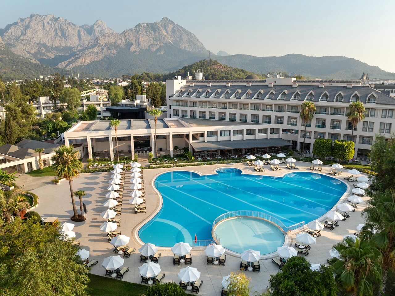 Mūsdienīgs viesnīcas komplekss ar plašu peldbaseinu, apkārtnē kalni un zaļa dārza zona. Ideāla vieta atpūtai un relaksācijai. panoramic view with beach and pools