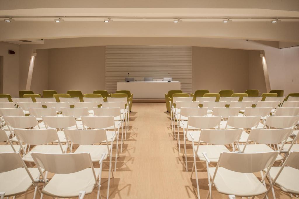 Konferenču telpa viesnīcā Cala Cuncheddi ar krēsliem un galdu.