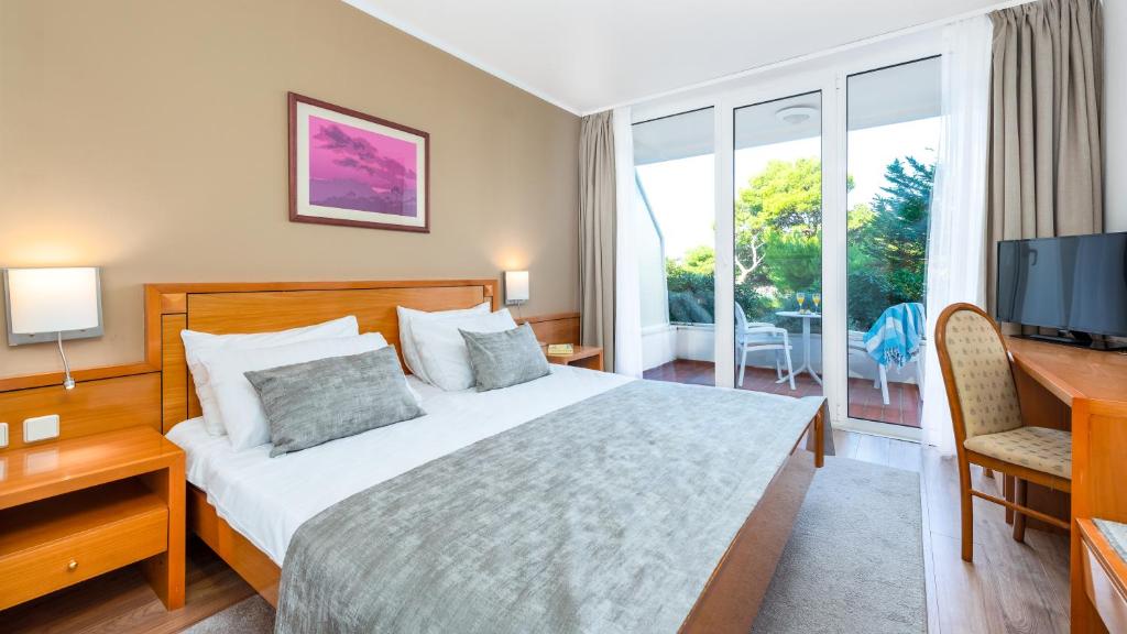 Mūsdienīgs viesnīcas numurs ar divguļamo gultu, koka mēbelēm un skatu uz dārzu. Telpā ir rakstāmgalds un televizors, kā arī lieli logi, kas nodrošina dabisko apgaismojumu.