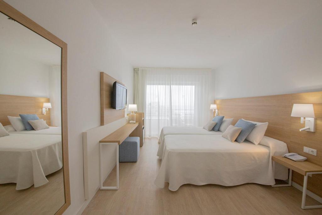 Mūsdienīgs viesnīcas numurs ar divām gultām, koka apdari un lieliem logiem, cauri kuriem ieplūst dabiska gaisma. Interjerā ir gaišas krāsas un minimālisma stils, radot relaksējošu atmosfēru.