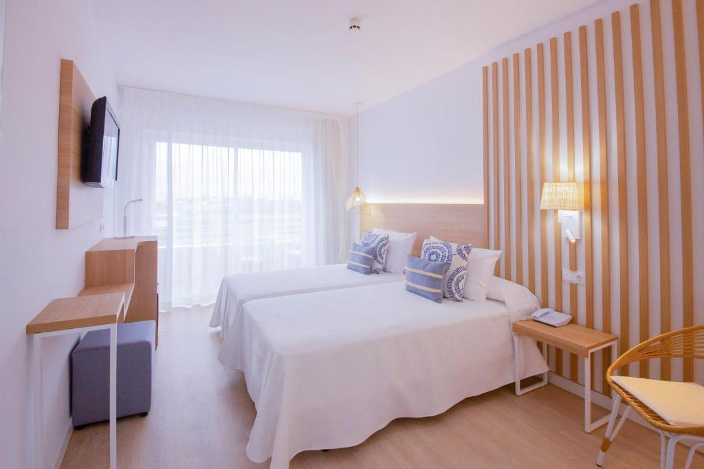 Mūsdienīgs viesnīcas numurs ar divām atsevišķām gultām, gaišām krāsām un koka akcentiem. Lielas logu aizkari nodrošina dabīgu apgaismojumu un skatu uz ārpusi.