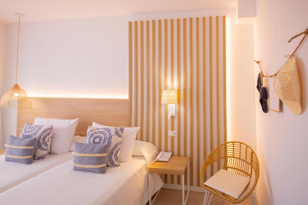 Mūsdienīgs viesnīcas numurs ar divām gultām, koka akcentiem un dekoratīvām spilveniem, kas piešķir komfortu un stilu. Gaismas elementi un ratiņu krēsls papildina telpas estētiku.