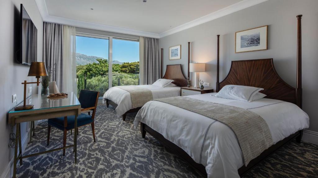 Mūsdienīgs viesnīcas numurs ar divām atsevišķām gultām, elegantu interjeru un gleznainu skatu pa logu. Interjers satur modernu mēbeli un mākslas darbus uz sienām.