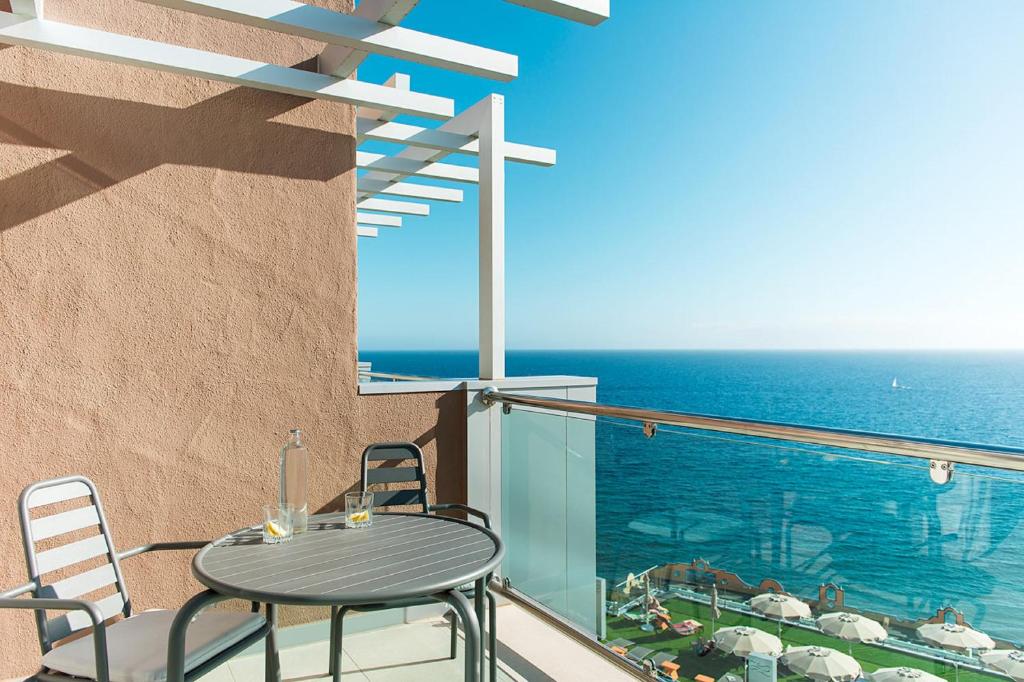 Balconā ar jūras skatu ir galds un krēsli, kas aicina atpūsties. Saulainā dienā var redzēt pludmali un saulessargus.